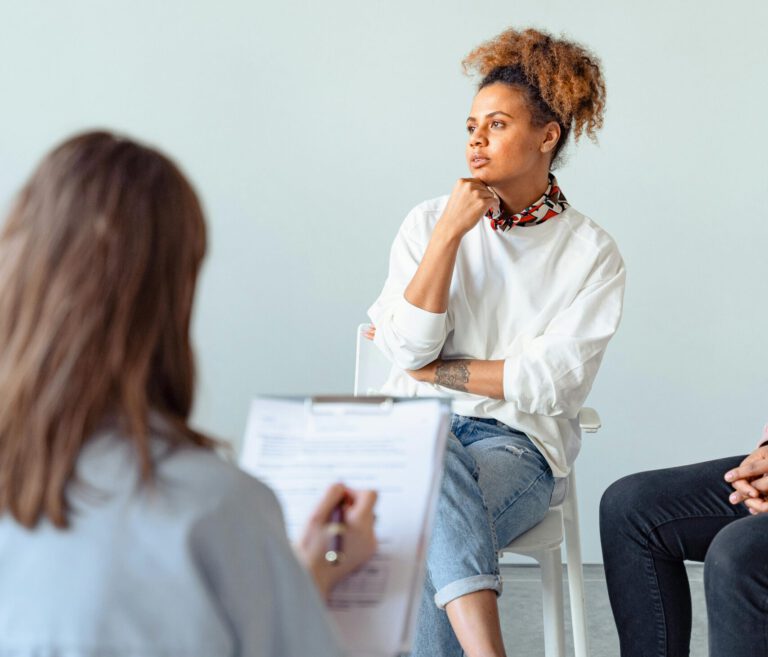 A thoughtful woman attending a counseling session with a professional indoors.