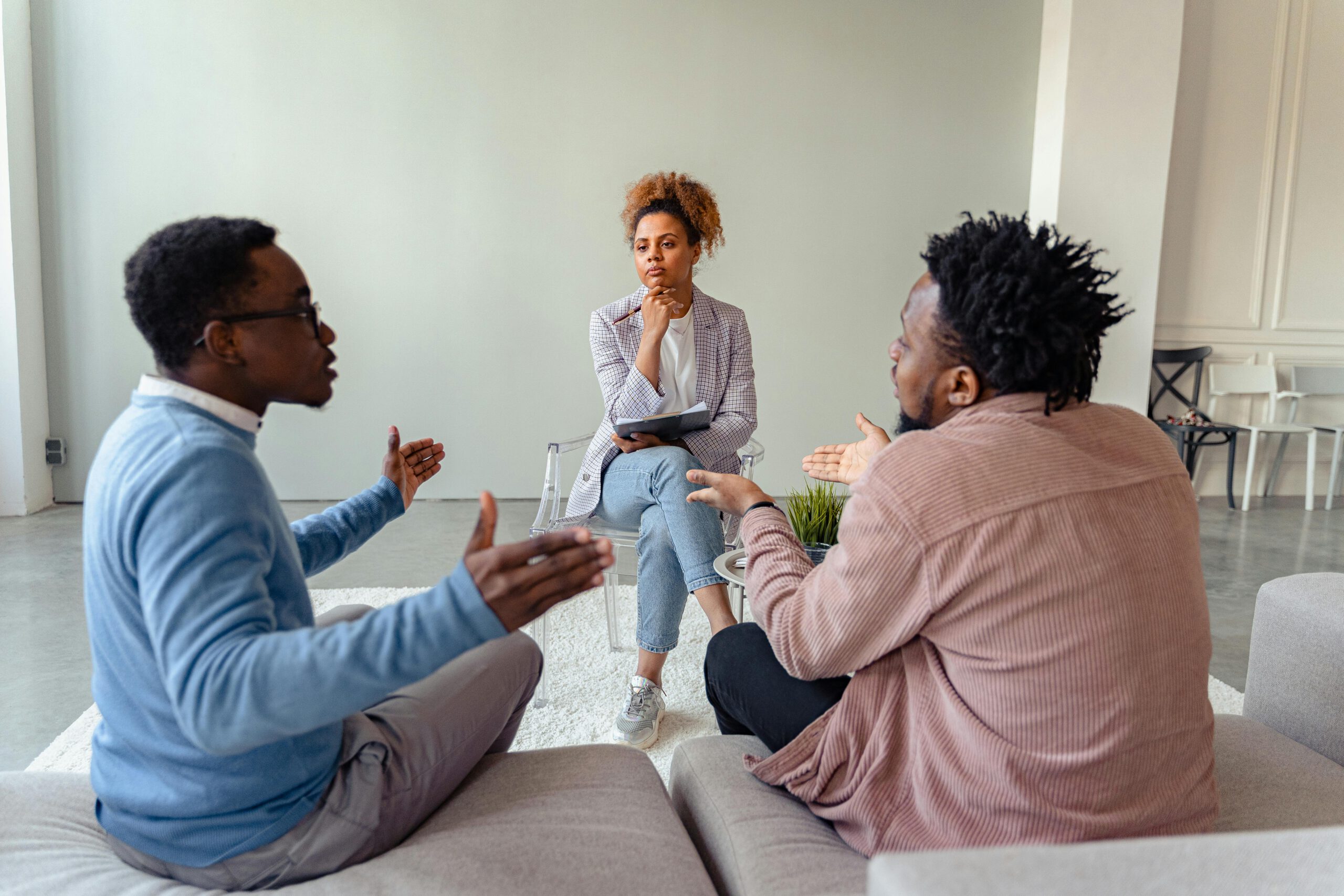 A therapy session featuring a diverse group discussing issues with a mental health professional.